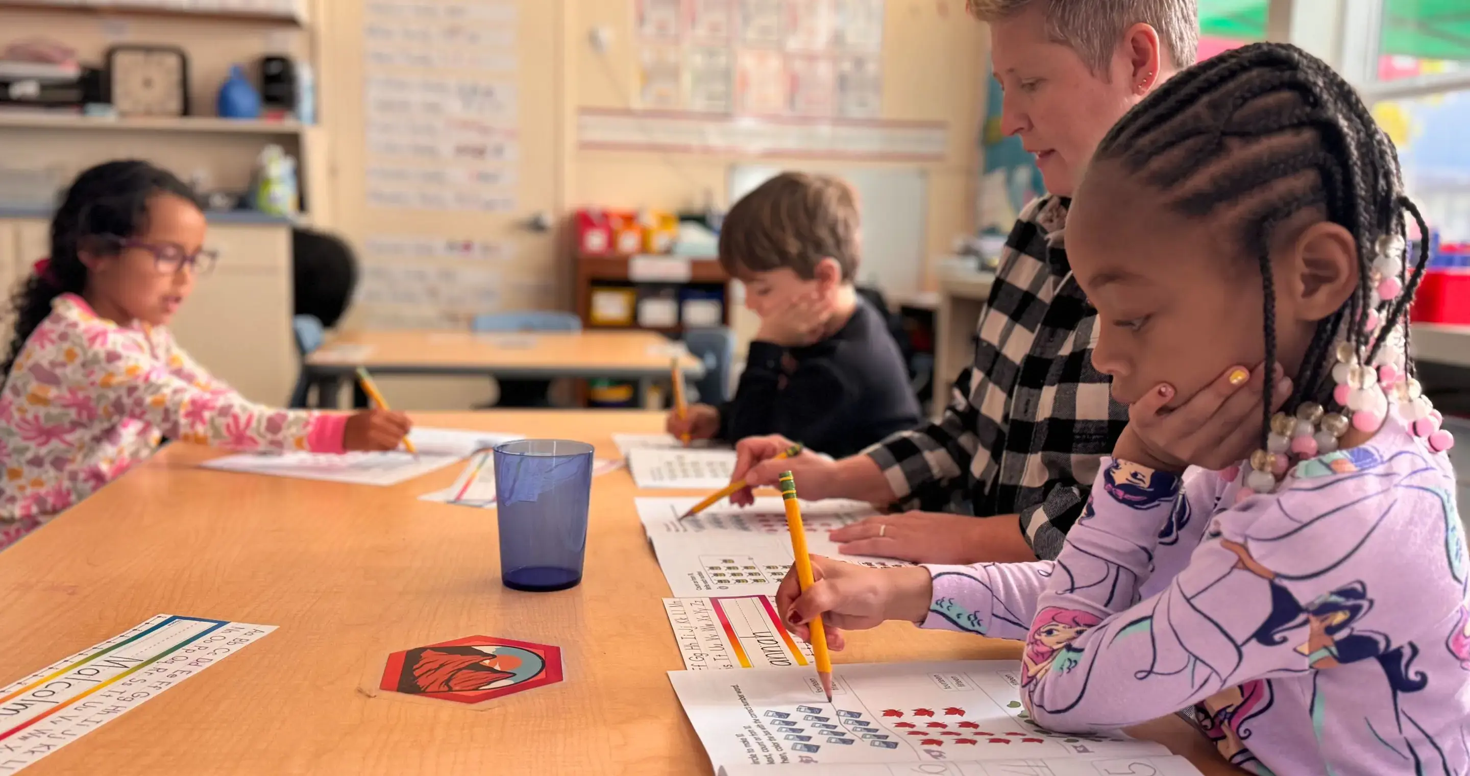 Three_kindergarteners_with_teacher_doing_math