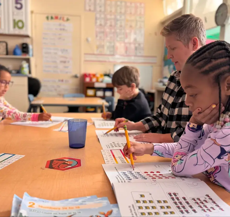 Three_kindergarteners_with_teacher_doing_math