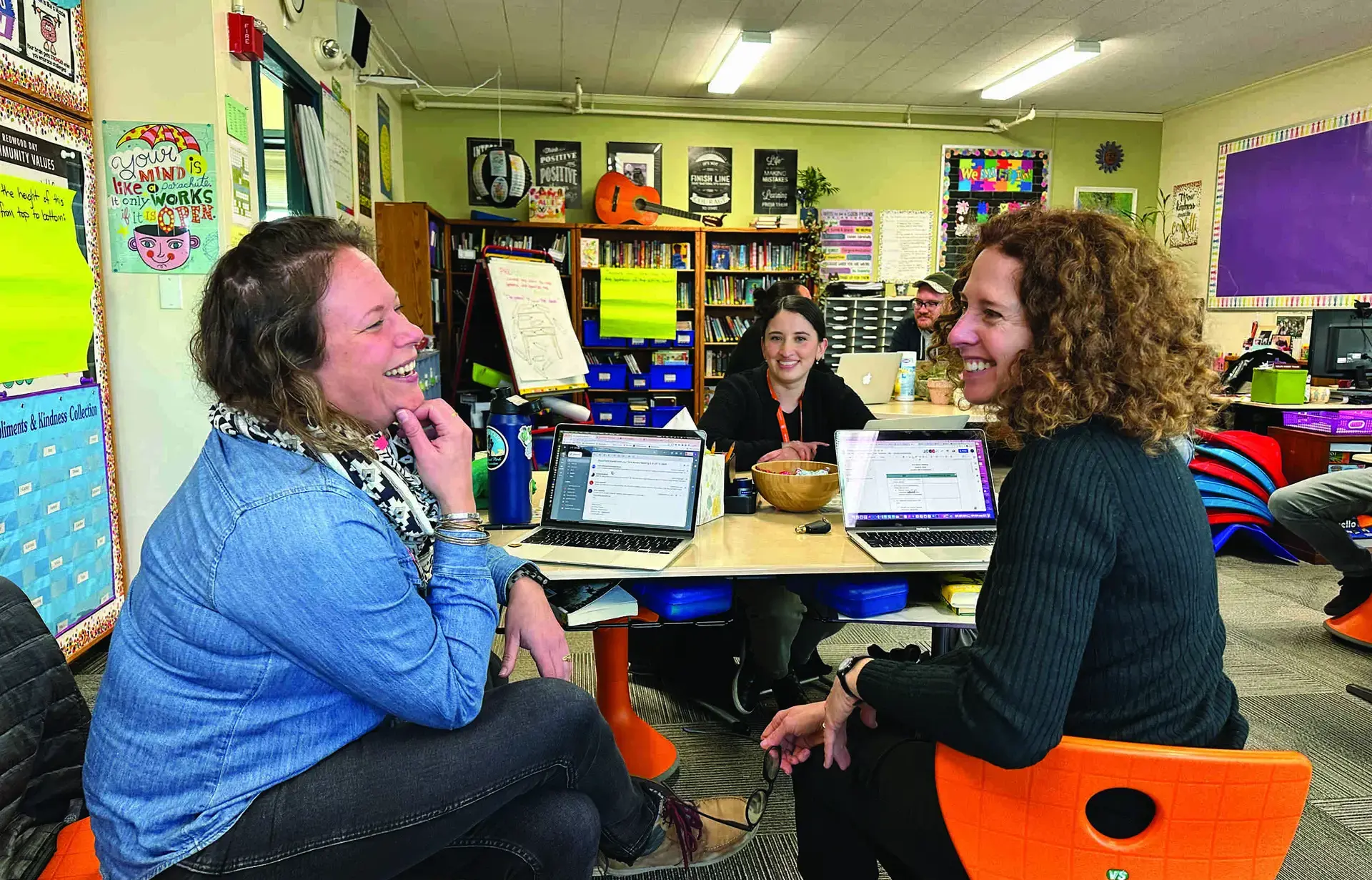 two adults chatting in classroom